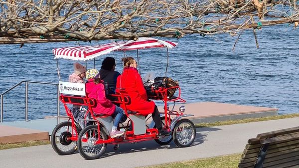 Familie fährt mit Happy Bike an der Donaulände 